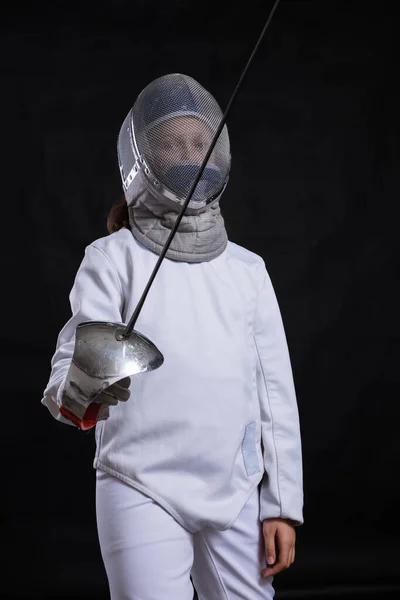 Tiener meisje fencer gekleed in uniform met epee en helm — Stockfoto