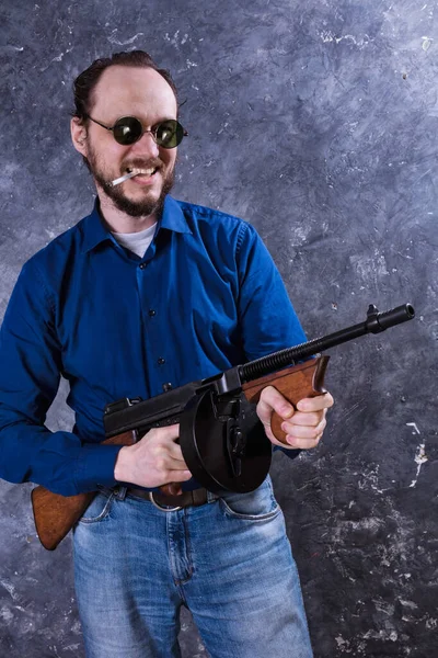 Reifer Mann mit Sonnenbrille und Pistole — Stockfoto
