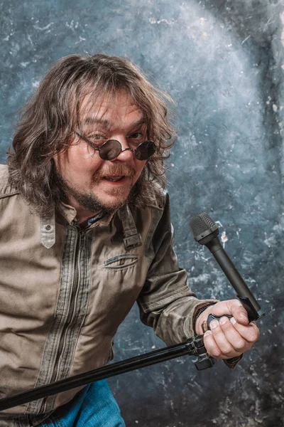 Mature rocker with microphone emotional studio portrait. — Stock Photo, Image