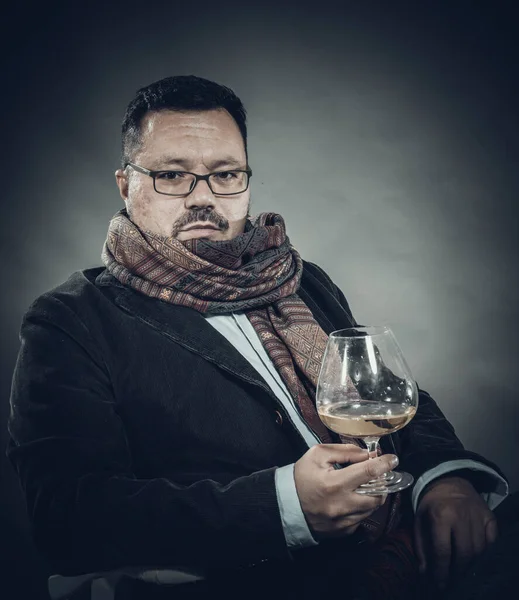 Solidní veselý muž v kapesníku, sedící se sklenicí vína — Stock fotografie