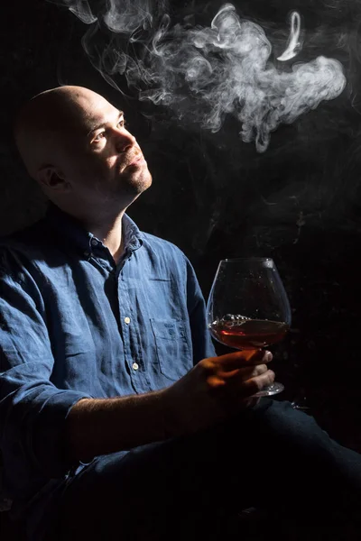 Solide kale man in shirt met glas whisky en rook studio portret. — Stockfoto