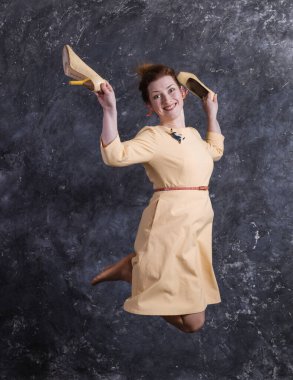 Bej elbise giymiş orta yaşlı neşeli bir kadın stüdyo portresi.