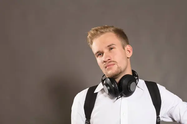 Jeune homme habillé en chemise blanche et avec écouteurs — Photo