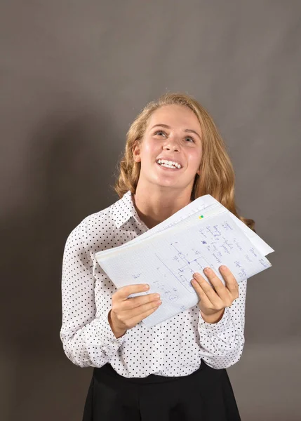 Unge, vakre, langhårete studentjente med papirer ser glad ut. – stockfoto