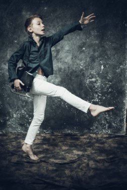 Beyaz kot ve mavi gömlek giymiş genç bir artistik patenci.