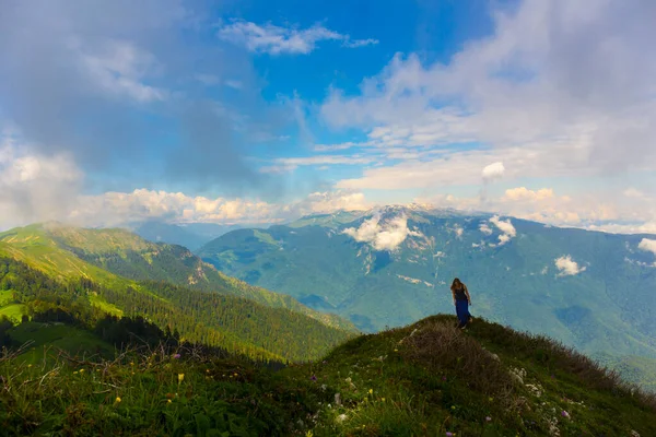 Hermoso paisaje de montaña en las montañas del Cáucaso con la mujer de pie lejos en la cresta —  Fotos de Stock