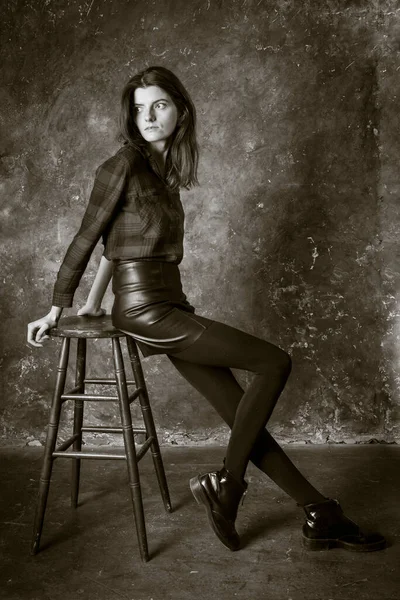 スタジオ肖像画の若い美しい女性です革のスカート — ストック写真