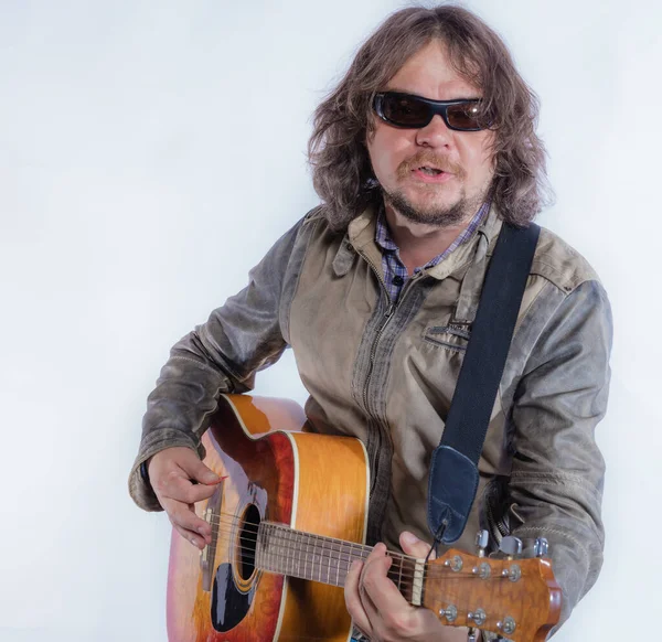 Mature musician plays acoustic guitar studio portrait. — Stock Photo, Image