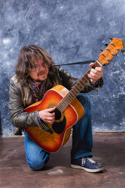 Mature musician plays acoustic guitar studio portrait. — Stock Photo, Image