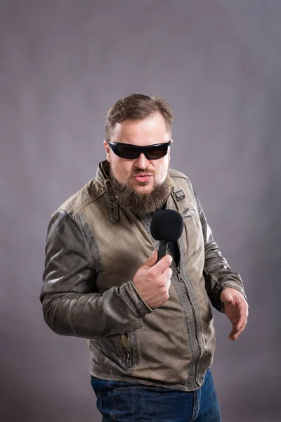 Bearded emotional rock singer with microphone studio portrait. — Stock Photo, Image