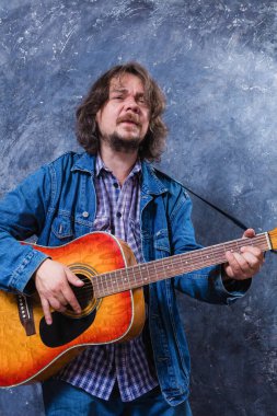 Olgun müzisyen akustik gitar stüdyo portresi çalıyor..