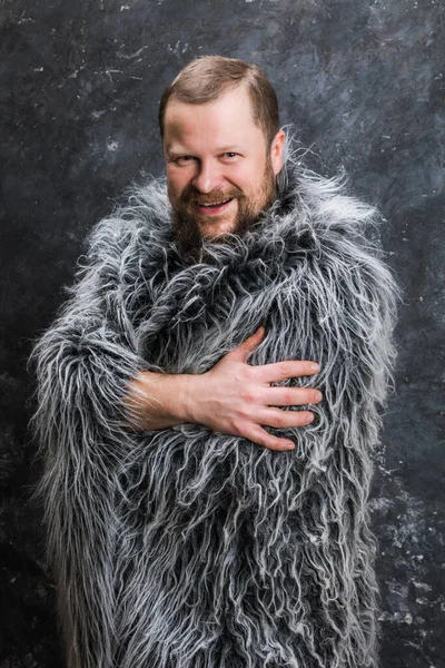 Solid bearded man in a fur skin