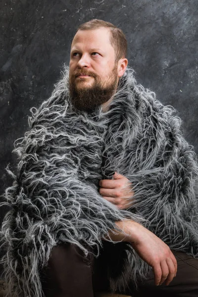 Solid bearded man in a fur skin