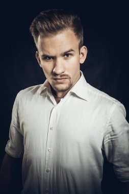 Beyaz gömlekli genç adam stüdyo resmi.