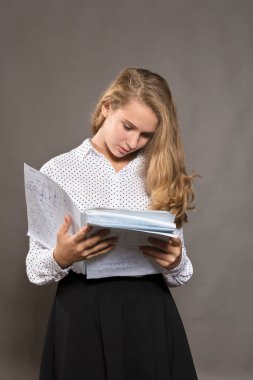 Evrakları olan güzel, uzun saçlı öğrenci kız mutlu görünüyor.