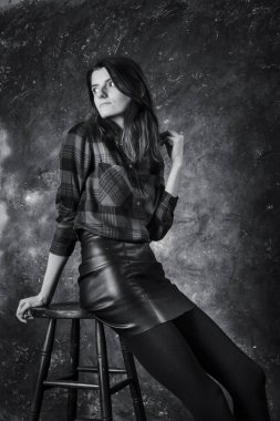 Deri etekli güzel bir kadının stüdyo portresi.