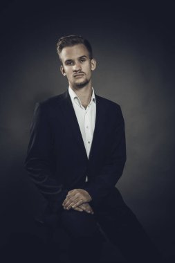 Takım elbiseli genç adam stüdyo resmi.