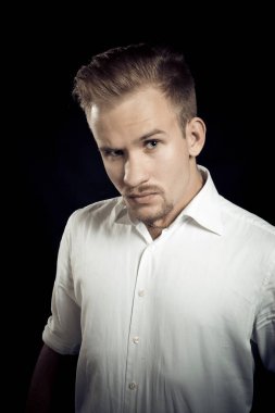Beyaz gömlekli genç adam stüdyo resmi.
