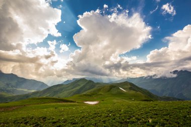 Kafkasya dağlarındaki güzel dağ manzarası Bulutlar ve mavi gökyüzü