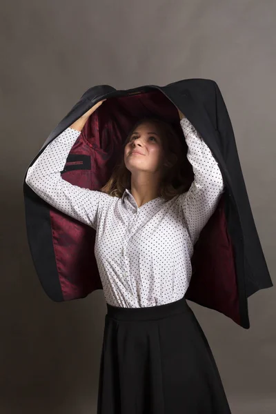 Jovem bela mulher alegre protegendo-se da chuva pelo casaco de homem — Fotografia de Stock