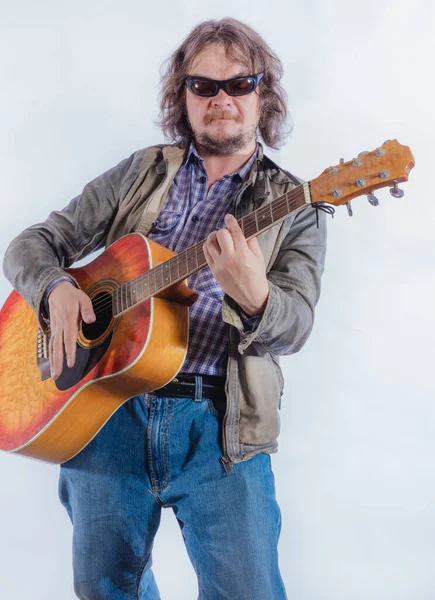 Mature musician plays acoustic guitar studio portrait. — Stock Photo, Image