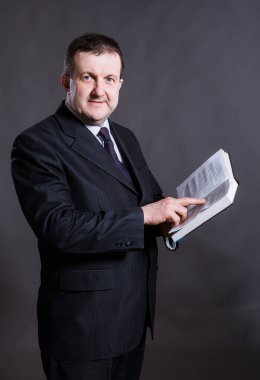 Orta yaşlı, kitap stüdyosu portresi olan sağlam bir öğretmen..