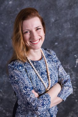 Mavi elbiseli neşeli orta yaşlı kadın.