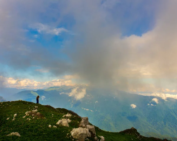 Hermoso paisaje de montaña en las montañas del Cáucaso con la mujer de pie lejos en la cresta —  Fotos de Stock