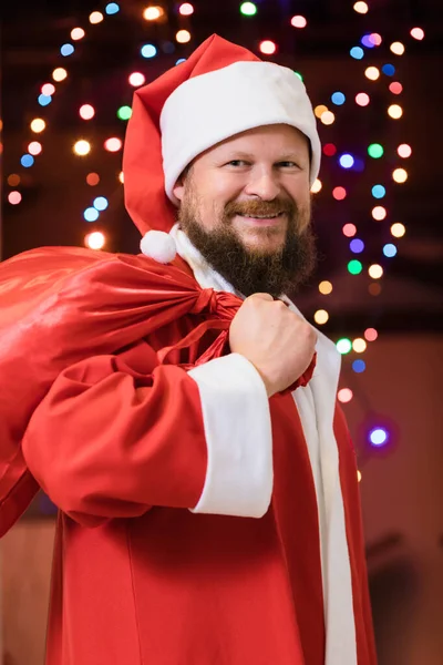 Bearded man dressed in Santa Claus costume with gifts — Stock Photo, Image