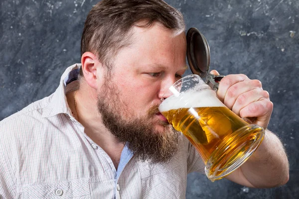 Matured lachende man met baard in shirt met bier mok — Stockfoto