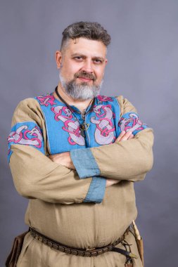 Geleneksel tarihi giysiler içinde olgun sakallı bir adam.