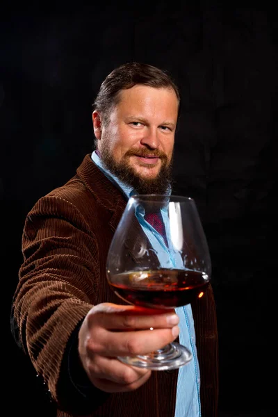 Elegante uomo barbuto vestito con giacca marrone con bicchiere di whisky — Foto Stock