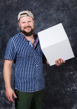 Logon için beyaz kübü olan tişörtlü neşeli sakallı adam.