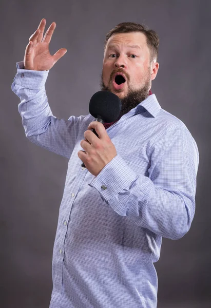 Bearded penyanyi emosional dengan mikrofon mengenakan kemeja potret studio. — Stok Foto