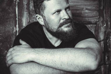 Olgun sakallı adam klasik kapının arkasında oturuyor.