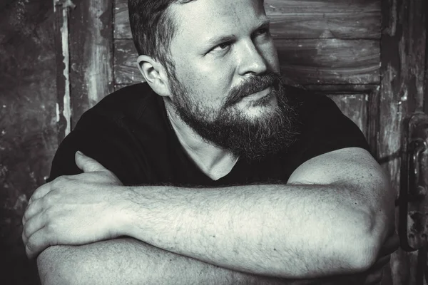 Olgun sakallı adam klasik kapının arkasında oturuyor.