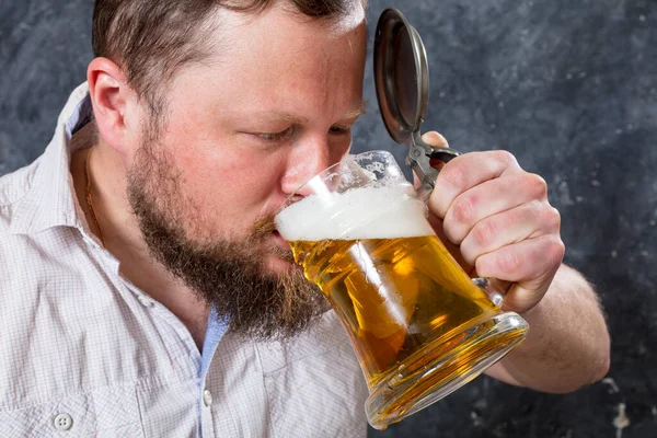 Matured lachende man met baard in shirt met bier mok — Stockfoto