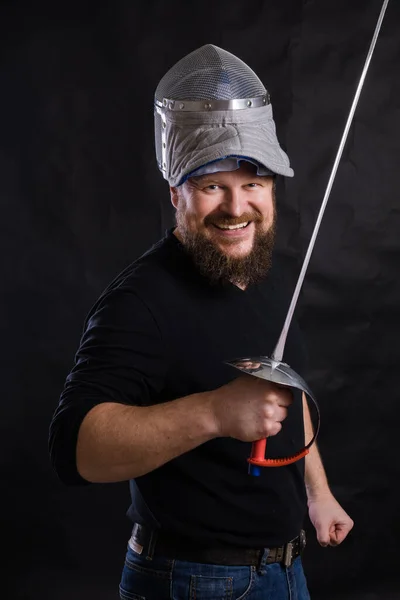 Hombre barbudo de mediana edad con epee y casco — Foto de Stock