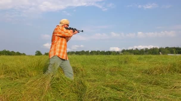 Hunter en gorra y gafas de sol apuntando a un arma — Vídeos de Stock