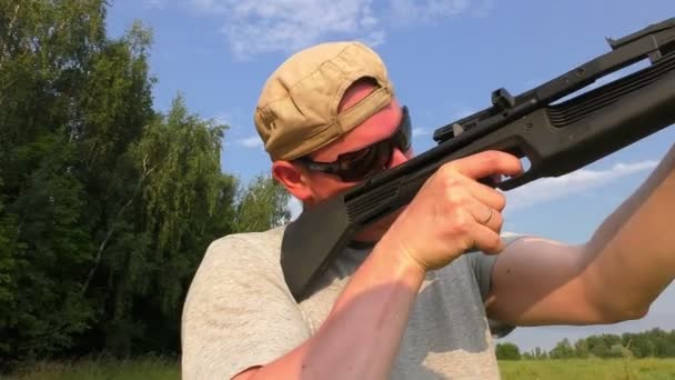 Hunter en gorra y gafas de sol apuntando a un arma — Vídeos de Stock