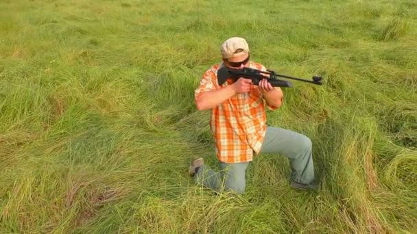 Hunter en gorra y gafas de sol apuntando a un arma — Vídeos de Stock