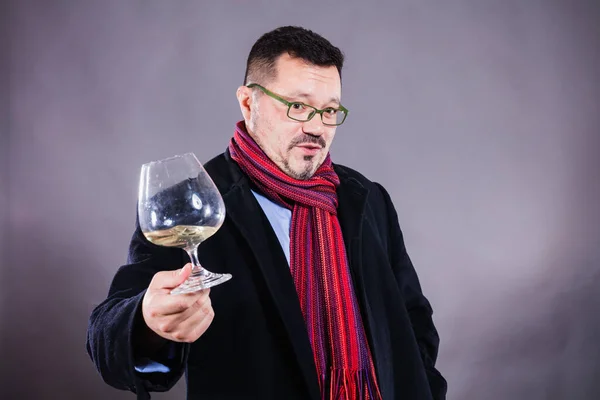 Hombre alegre sólido en abrigo y pañuelo de pie con copa de vino — Foto de Stock