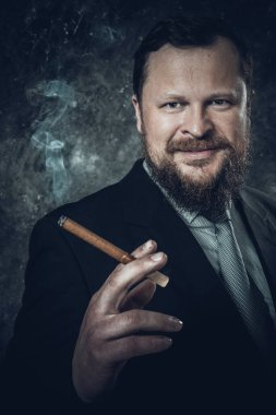 Purolu, dumanlı, sakallı adam.