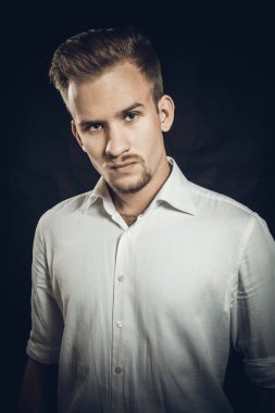 Beyaz gömlekli genç adam stüdyo resmi.