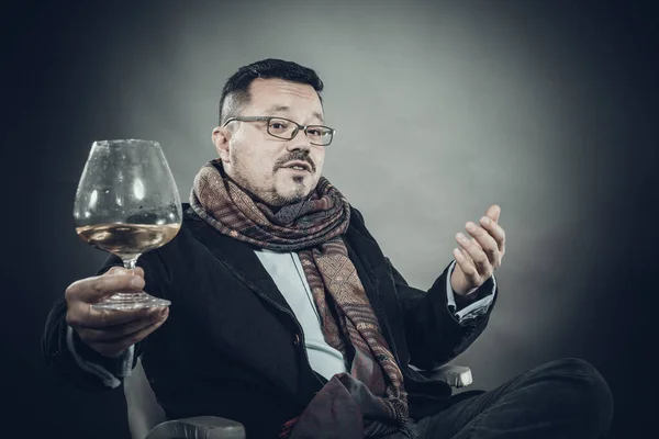 Hombre alegre sólido en pañuelo sentado con copa de vino — Foto de Stock