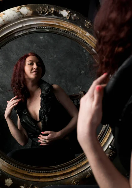 Vacker ung kvinna tittar på sin spegelbild — Stockfoto