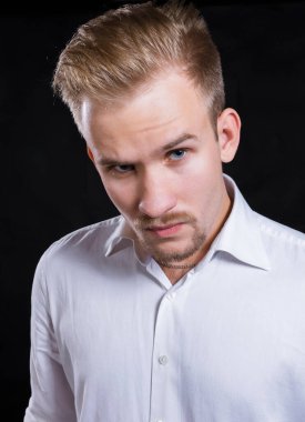 Beyaz gömlekli genç adam stüdyo resmi.