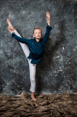 Beyaz kot ve mavi gömlekli genç dansçı stüdyo portresi yapıyor.