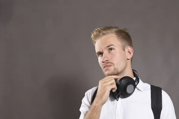 Jeune homme habillé en chemise blanche et avec écouteurs — Photo