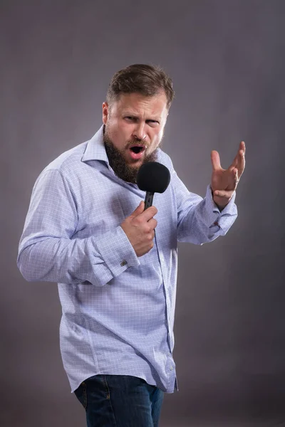 Bärtiger emotionaler Sänger mit Mikrofon im Shirt-Studio-Porträt. — Stockfoto